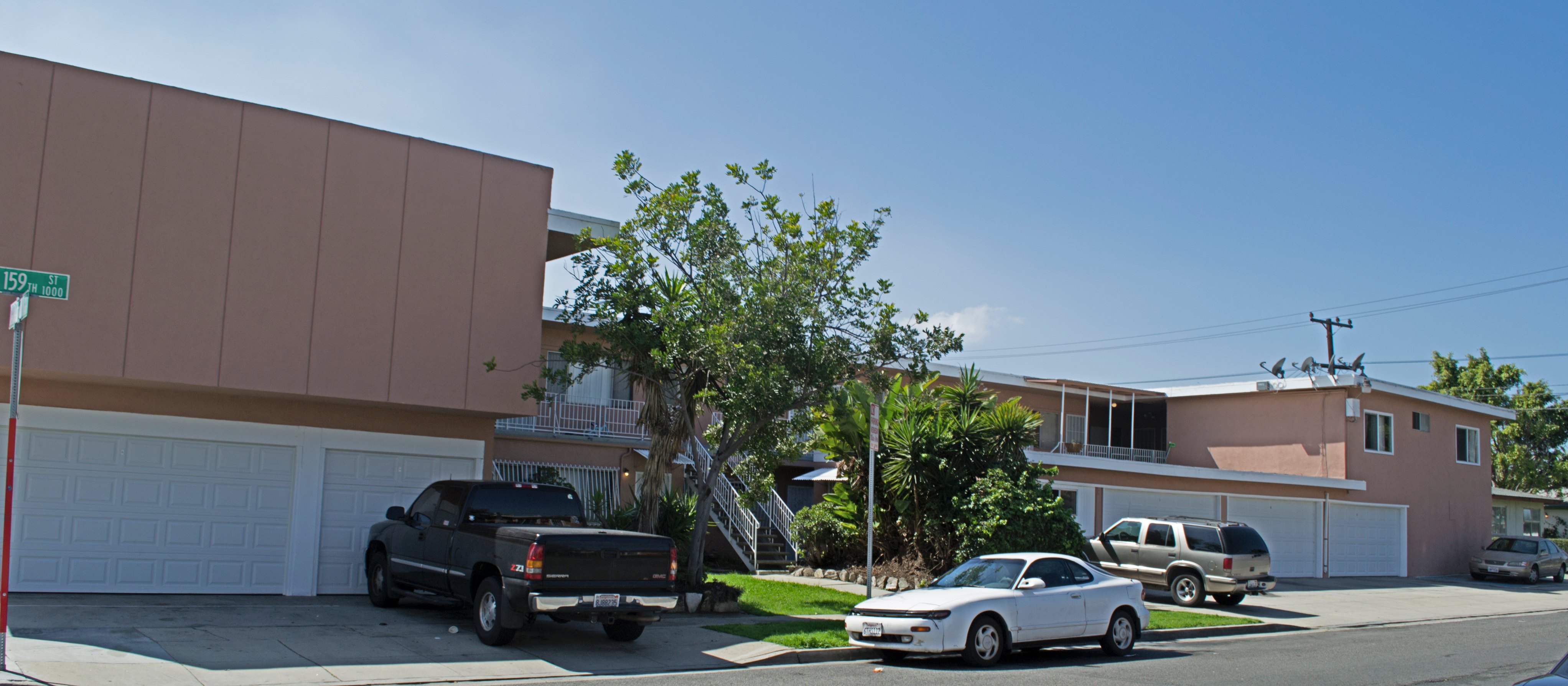 A black truck is parked in front of a white garage door.